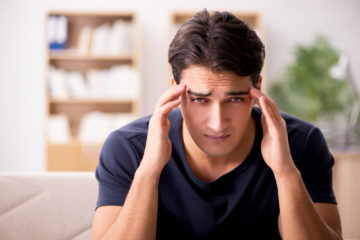 Man with a headache holding his temples